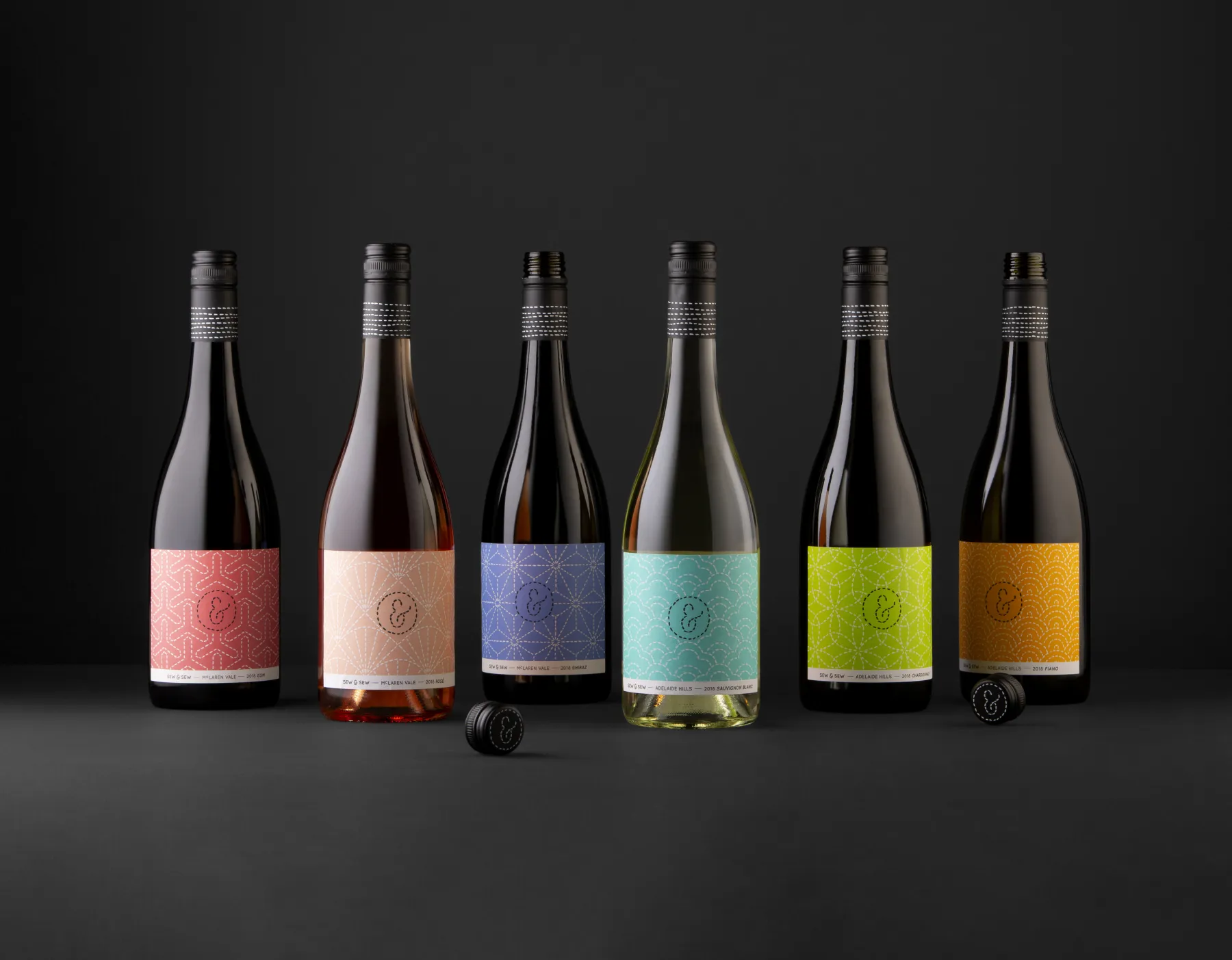 Six Sashiko wines in a row, each label a different colour of stitched Japanese pattern